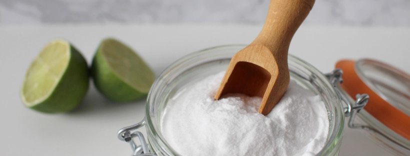 Un bol de bicarbonate de soude posé près d'un citron coupé en deux