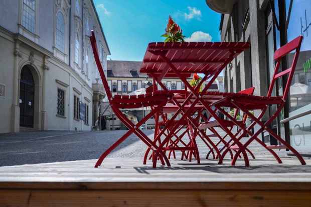 Une terrasse en bois avec des meubles rouges